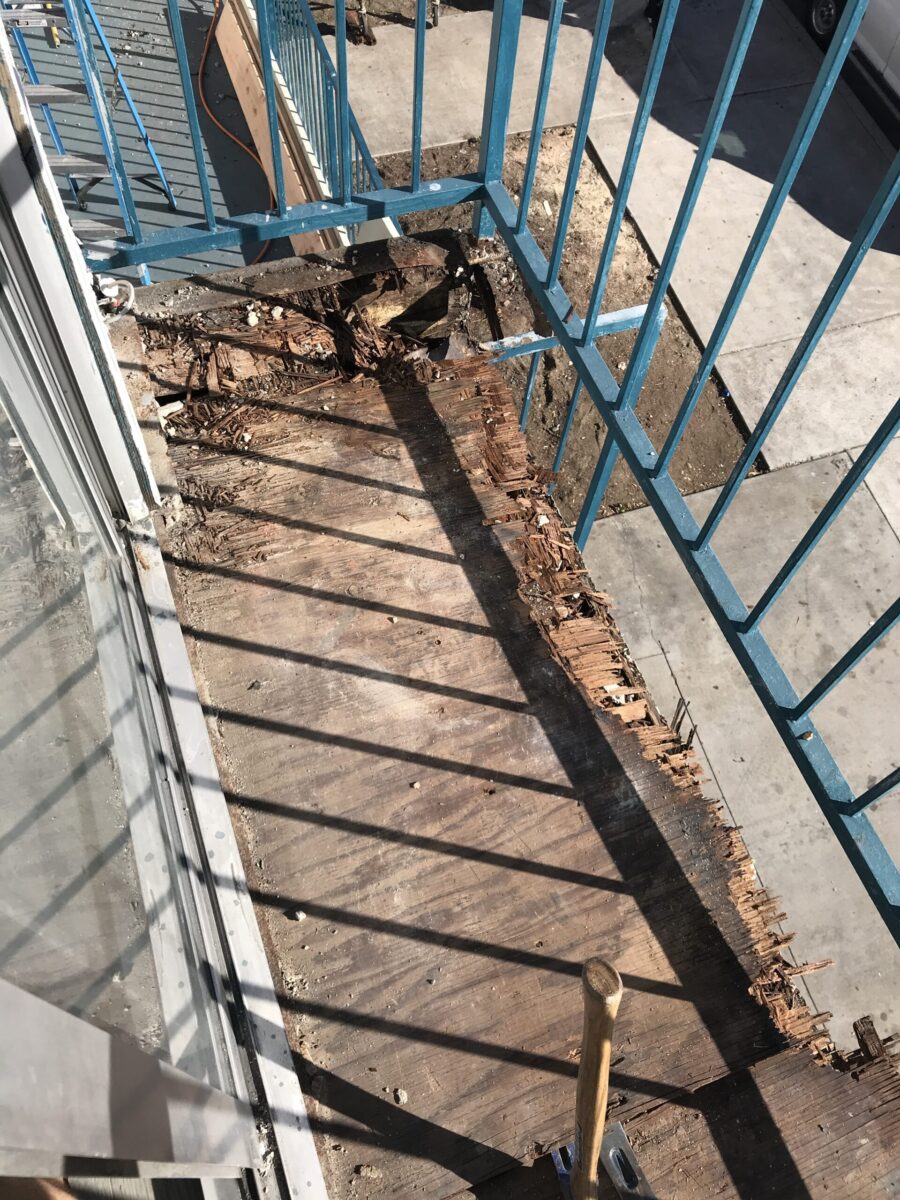 Rusty metal railing casting shadows on a wooden deck.