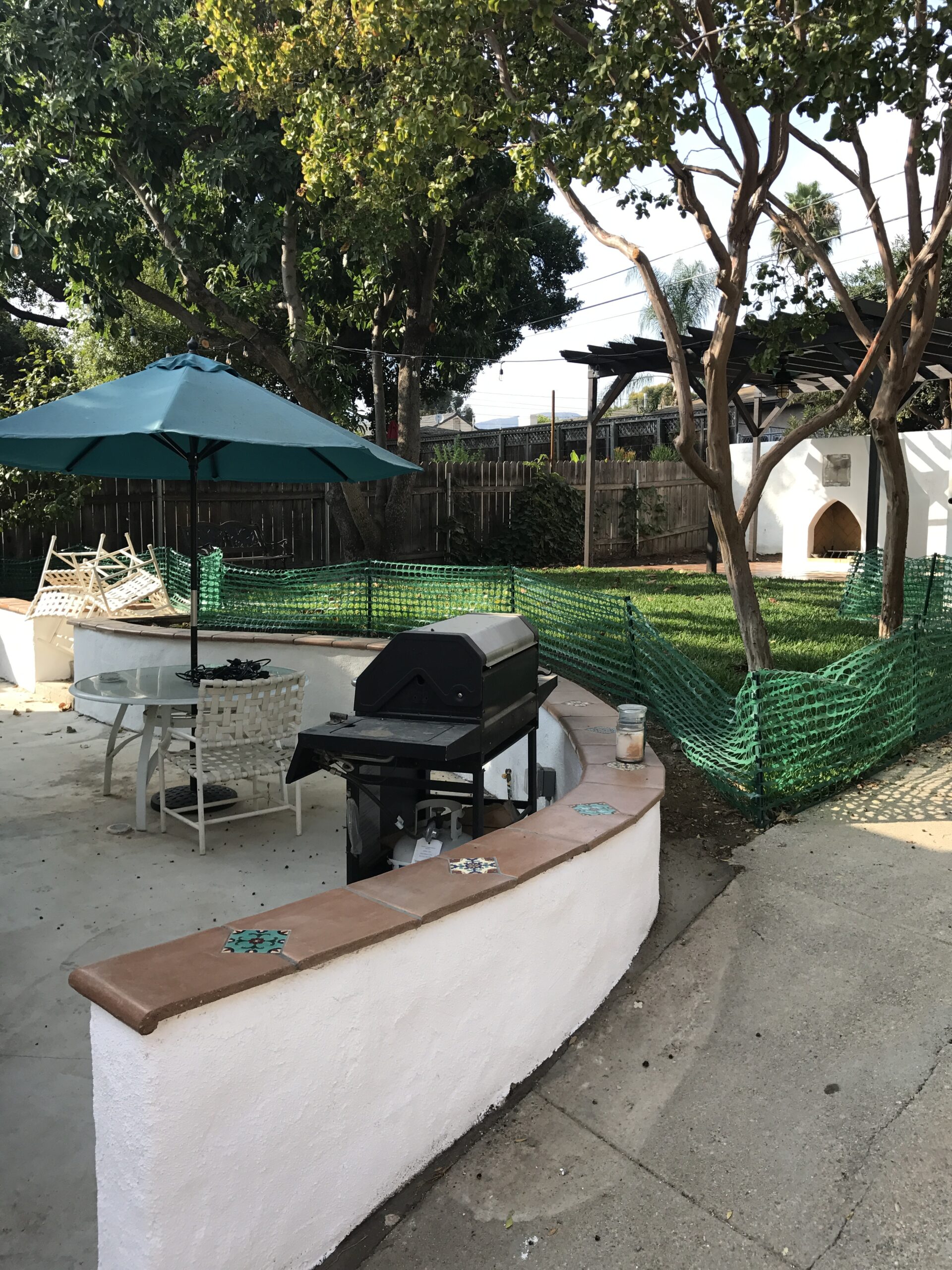 Outdoor patio with grill and umbrella.