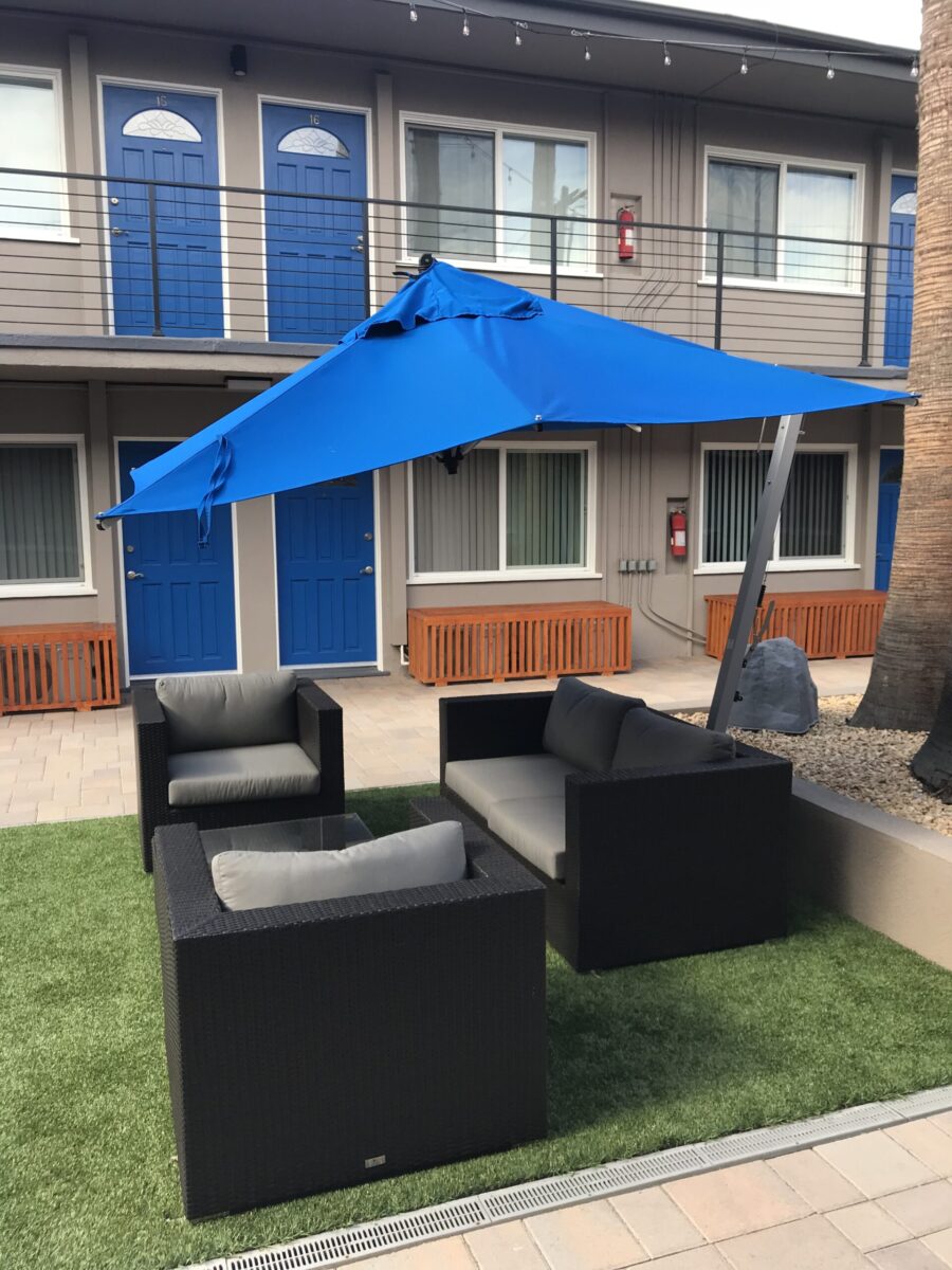 Outdoor patio set with blue umbrella on artificial grass. Outdoor patio set with blue umbrella on artificial grass.