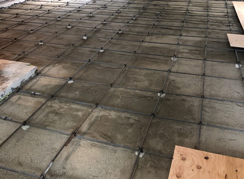 Concrete slab with embedded steel rebar grid under construction.
