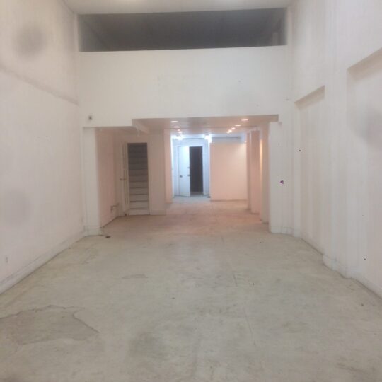 Empty, spacious room with white walls and concrete floor. Empty, spacious room with white walls and concrete floor.
