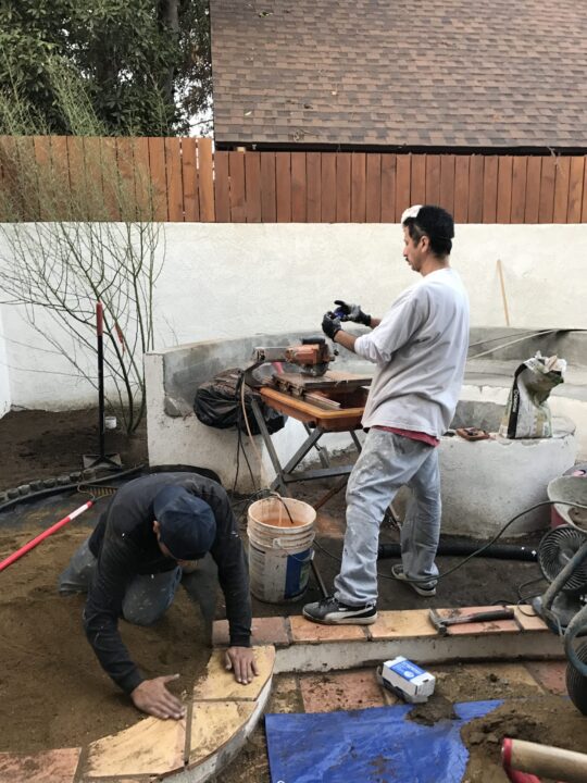 Two men working on a woodworking project outdoors. Two men working on a woodworking project outdoors.