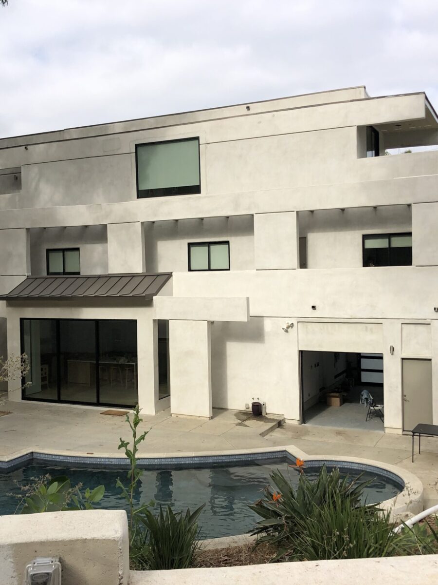Modern concrete house with a pool under a cloudy sky. Modern concrete house with a pool under a cloudy sky.