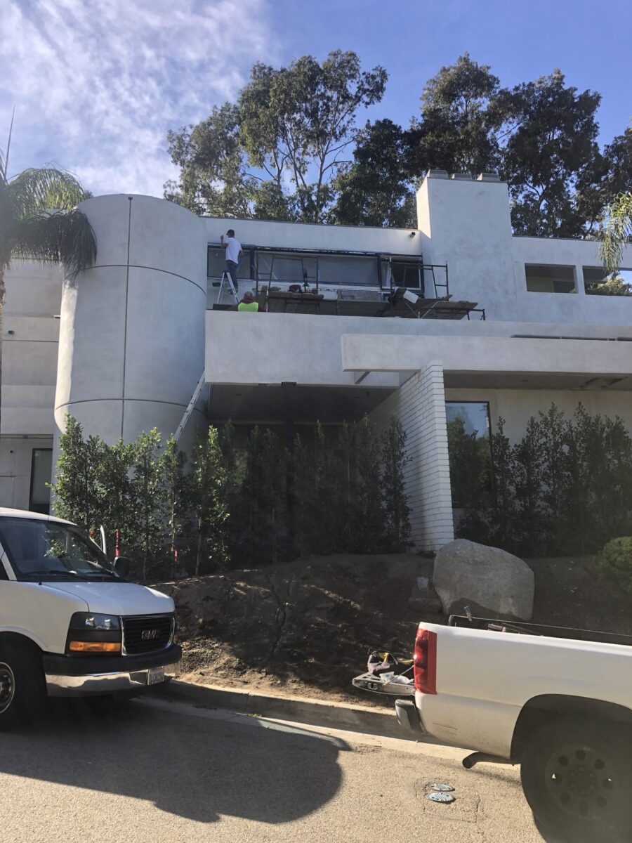Modern white building with large windows and surrounding greenery. Modern white building with large windows and surrounding greenery.