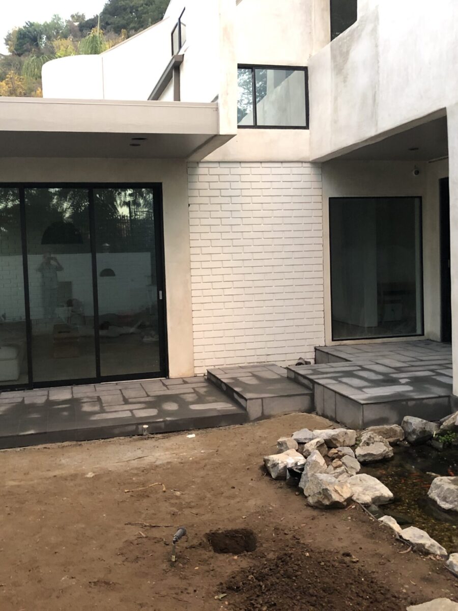A modern courtyard with glass doors and a dry garden area. A modern courtyard with glass doors and a dry garden area.