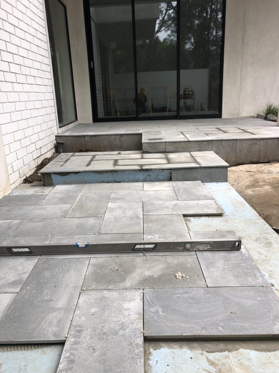 Unfinished outdoor patio with stone tiles being installed. Unfinished outdoor patio with stone tiles being installed.