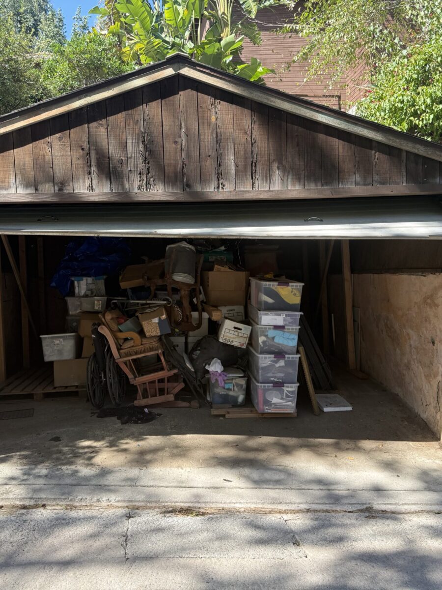 An open garage cluttered with stacked boxes and miscellaneous items.