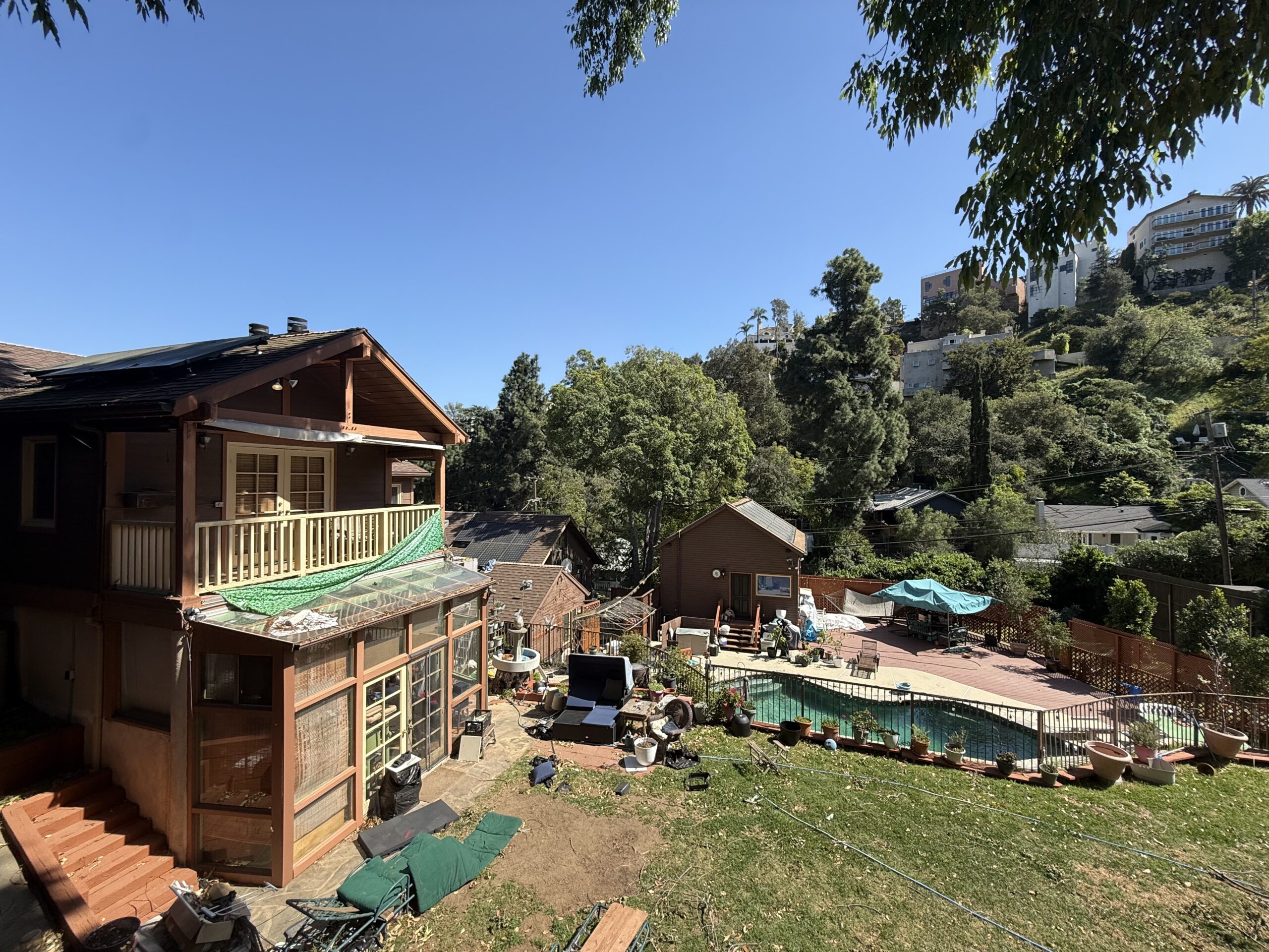 Rustic wooden cabins nestled in a sunny, green hillside setting.