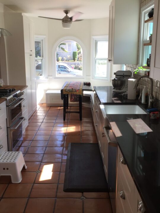 Bright kitchen with wooden cabinets and dining area at the window. Bright kitchen with wooden cabinets and dining area at the window.