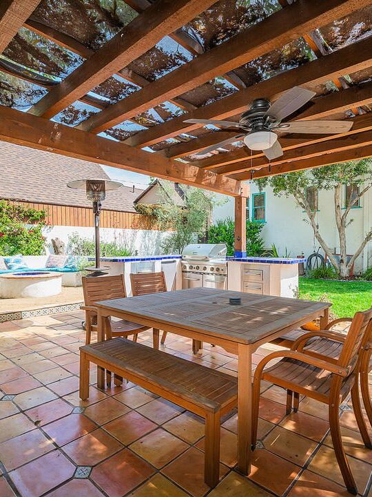 Cozy outdoor dining area with wooden furniture and tiled floor. Cozy outdoor dining area with wooden furniture and tiled floor.