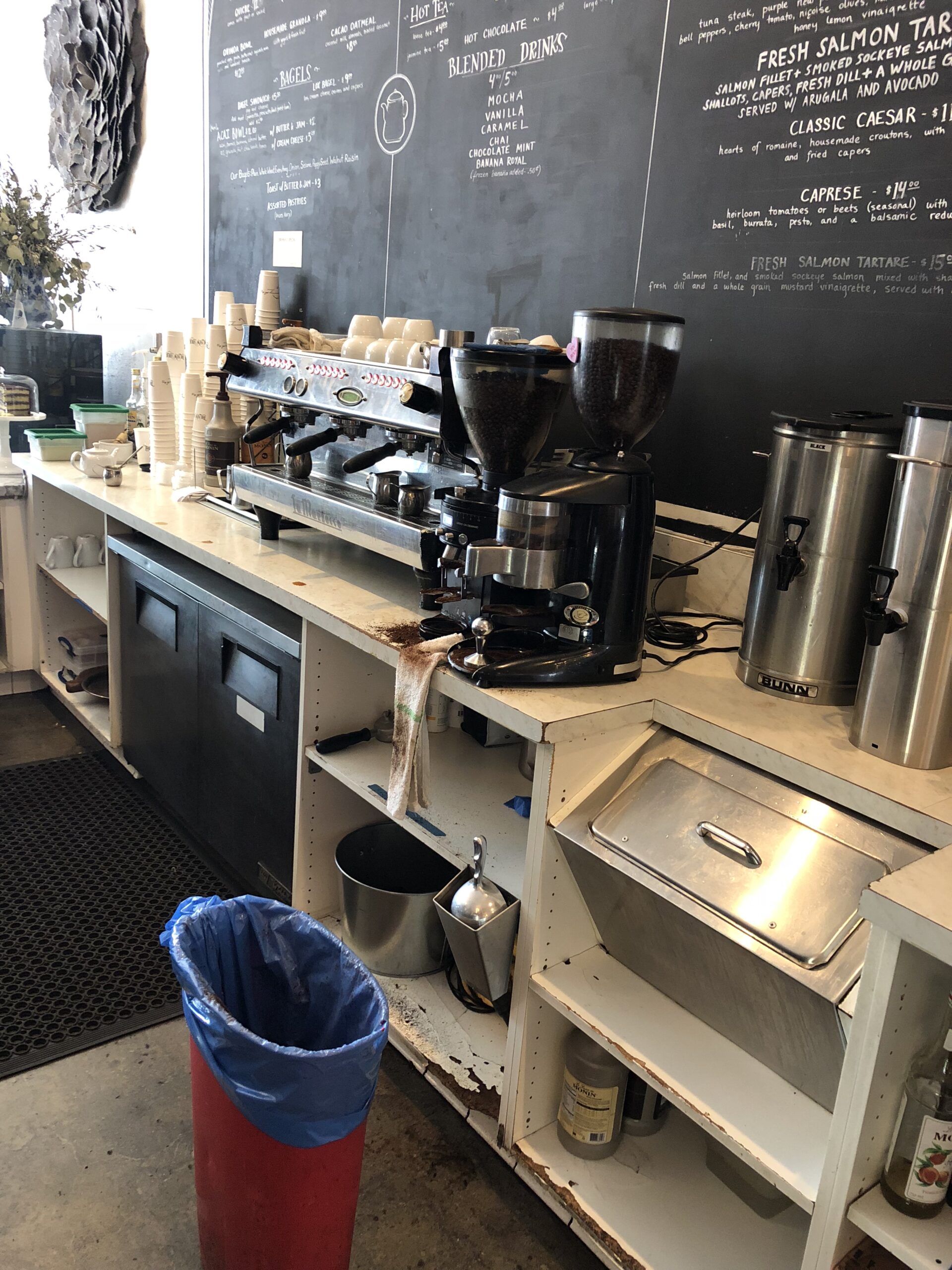 Modern coffee shop counter with espresso machine and grinder.